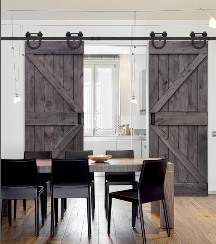 A dining room with a table and chairs and sliding barn doors