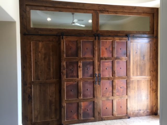 A room with sliding barn doors and a ceiling fan
