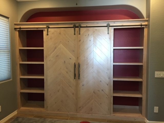 A room with a sliding barn door and shelves