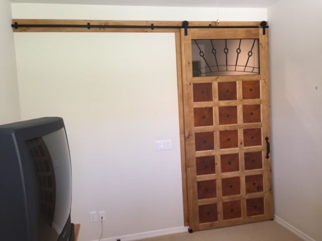 A room with a sliding barn door and a television