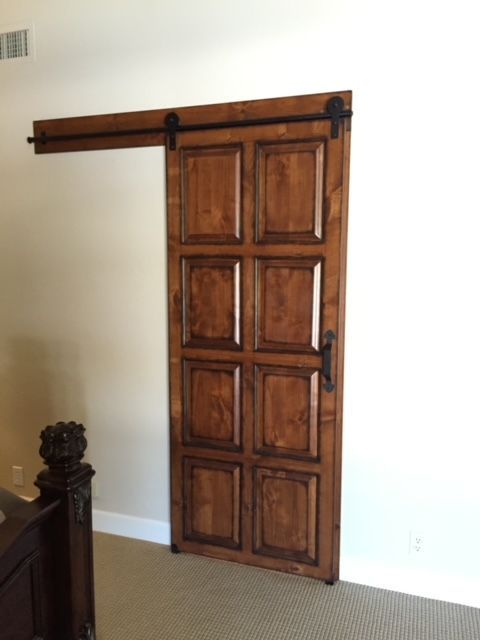 A bedroom with a wooden sliding barn door