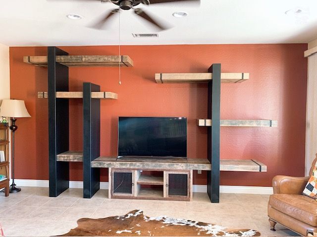 A living room with a ceiling fan and a flat screen television