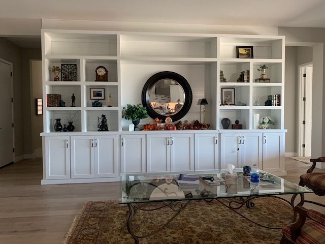 A living room with a lot of shelves and a coffee table
