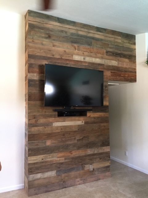 A flat screen television mounted on a wooden wall