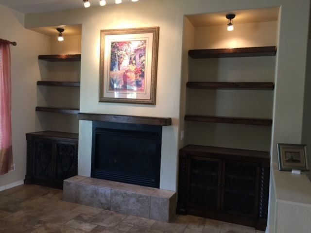 A living room with a fireplace and shelves