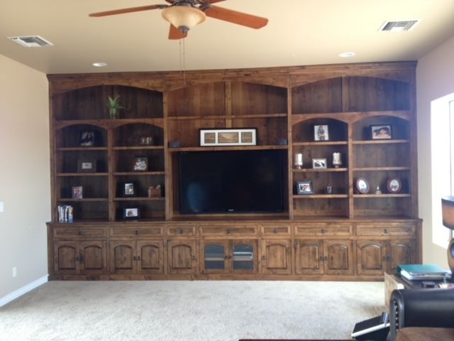 A living room with wooden cabinets and a flat screen television