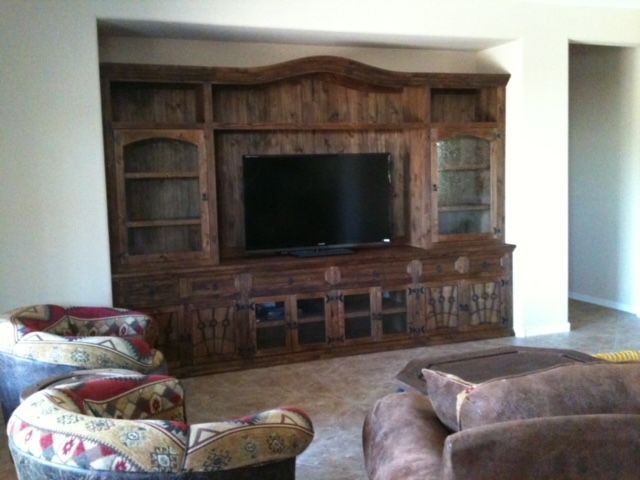 A living room with a large entertainment center and a flat screen television