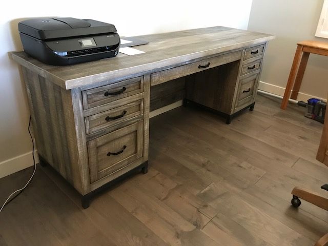 A printer is sitting on top of a wooden desk