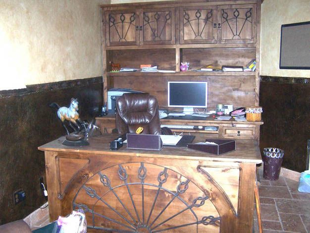 A wooden desk with a computer on it