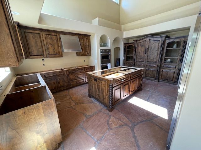 A kitchen with wooden cabinets and a large island in the middle