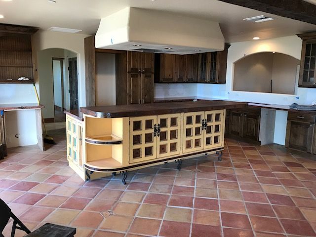 A large island in the middle of the kitchen surrounded by wooden cabinets