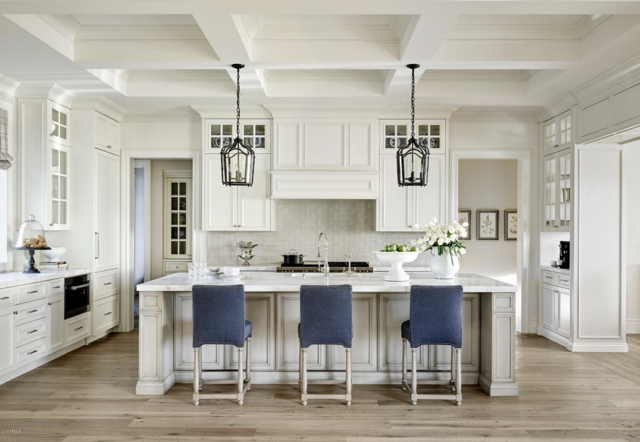 A kitchen with white cabinets and a large island
