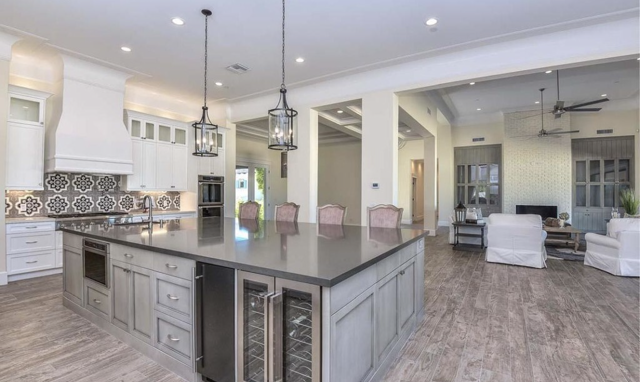 A large island with gray cabinets is in the middle of a kitchen