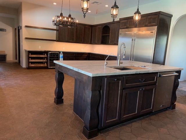 A kitchen with a large island, wooden cabinets, and stainless steel appliances