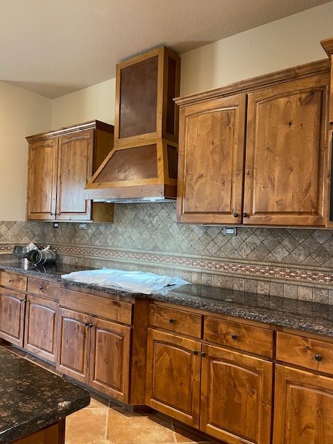 A kitchen with wooden cabinets and granite counter tops