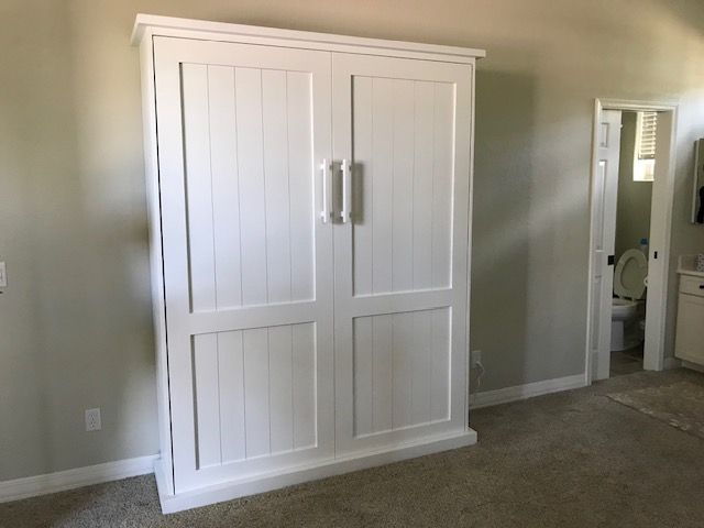 A white Murphy bed is sitting in a bedroom