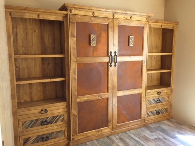 A room with wooden Murphy bed and shelves and drawers