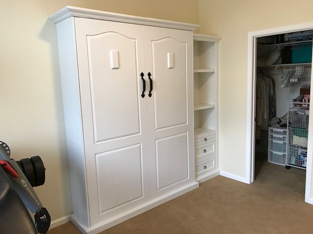 A white Murphy bed is sitting in a room next to a closet