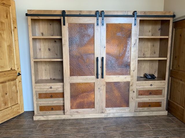 A wooden Murphy bed with sliding doors and drawers