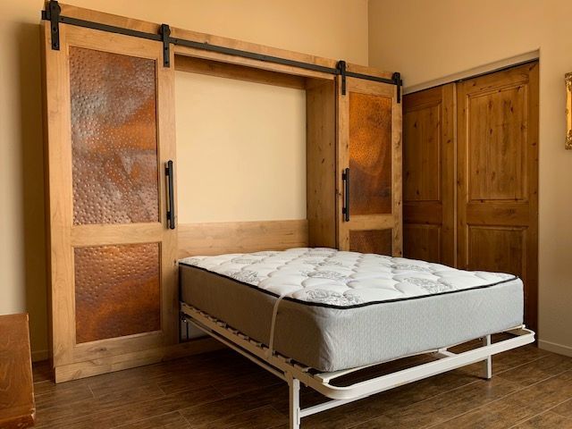 An open Murphy bed in a bedroom