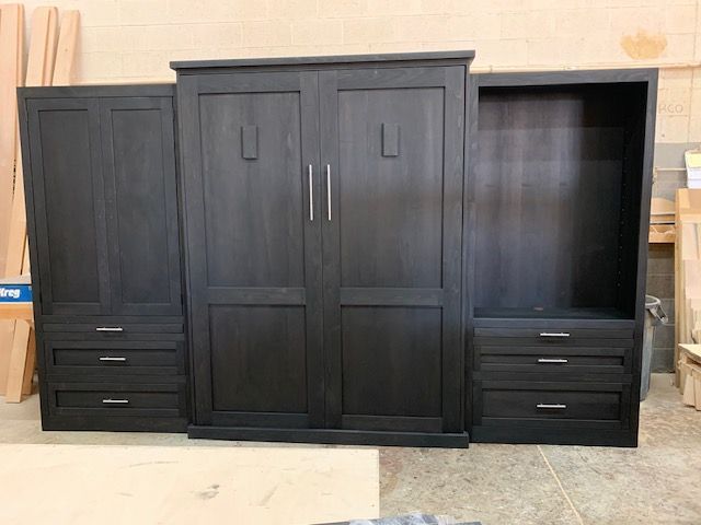 A large black Murphy bed with drawers