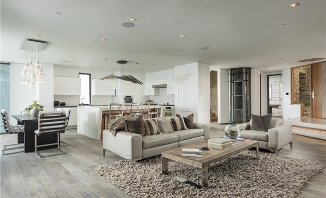 A living room with a couch, chairs, coffee table and rug