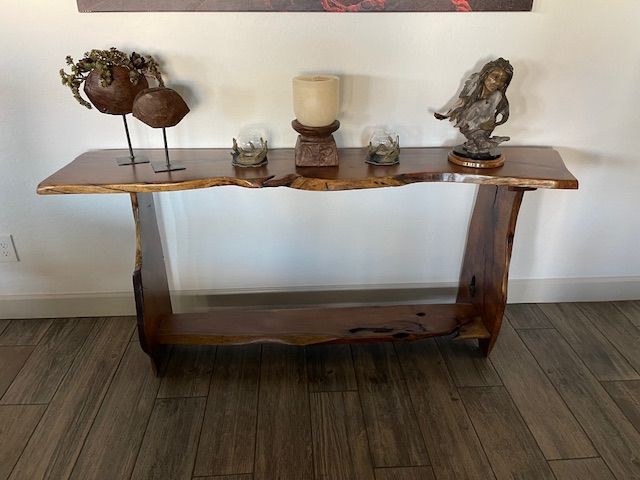 A wooden table with candles and statues on it