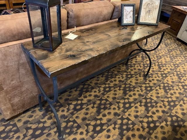 A wooden table is sitting next to a couch in a living room