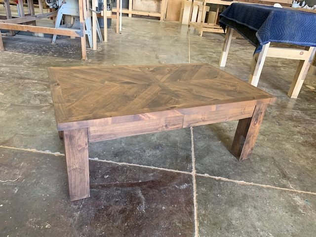 A wooden table is sitting on a concrete floor in a room