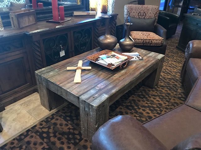 A wooden coffee table with a cross on it in a living room