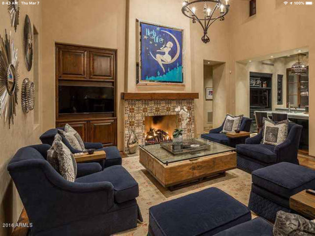 A living room with a fireplace and a painting on the wall