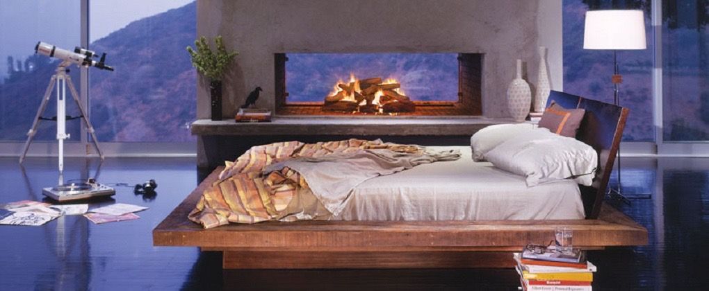 a bedroom with a bed a fireplace and a telescope