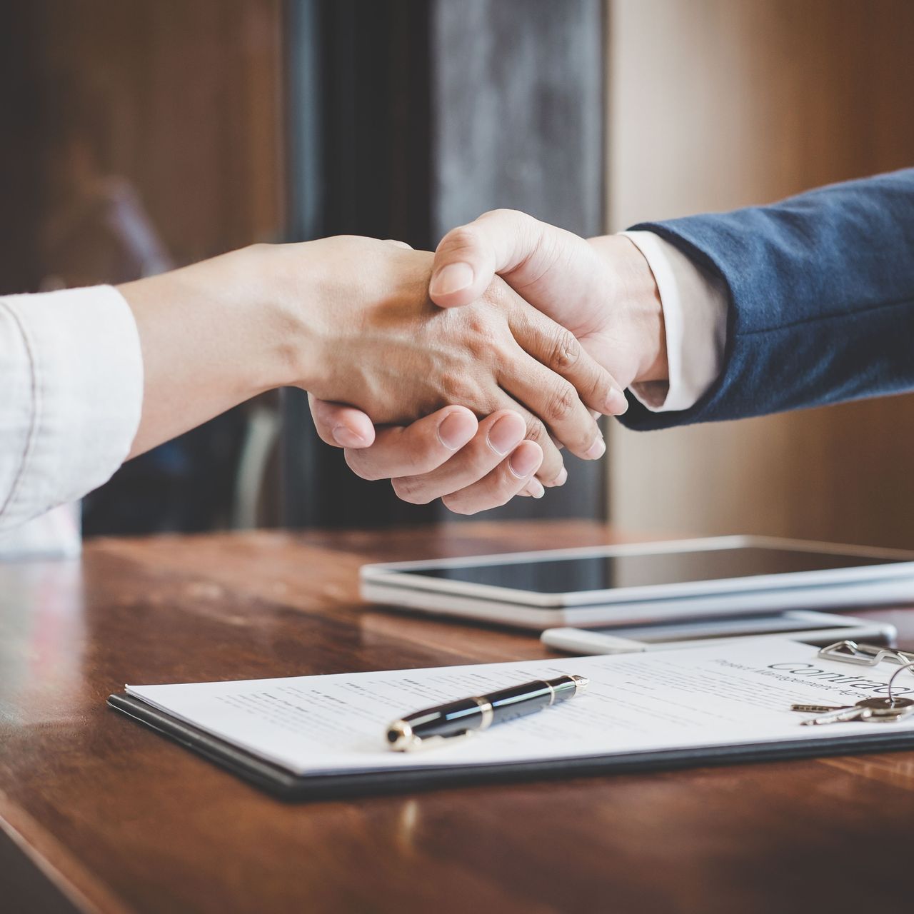 a man and a woman shake hands over a contract