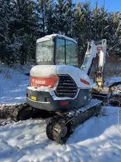 Bobcat excavator in a snowy field.
