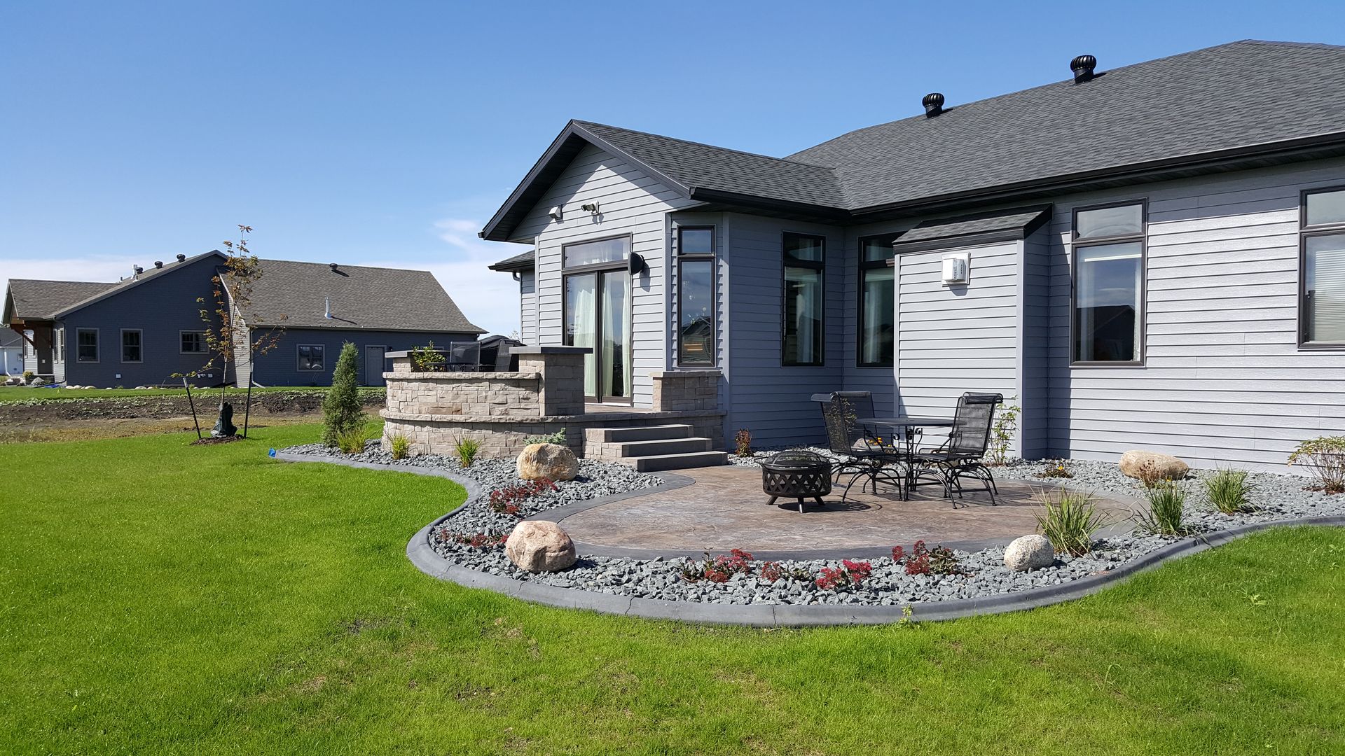 A house with a patio and a fire pit in the backyard.