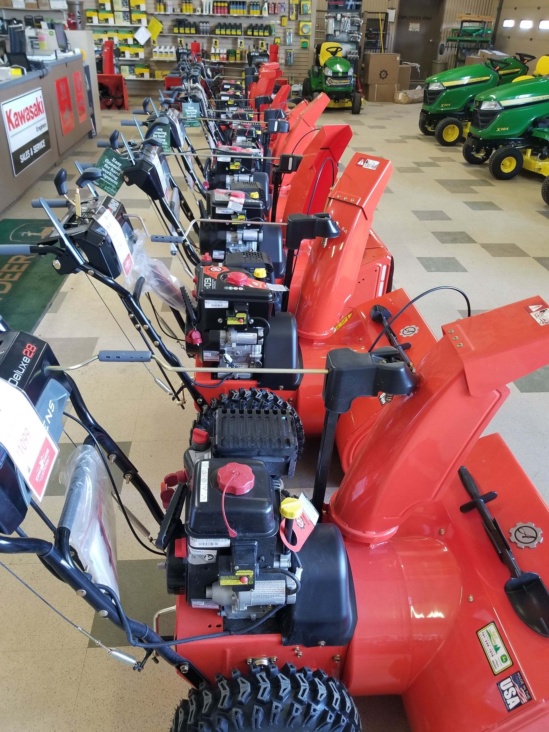 A row of snow blowers are lined up in a store