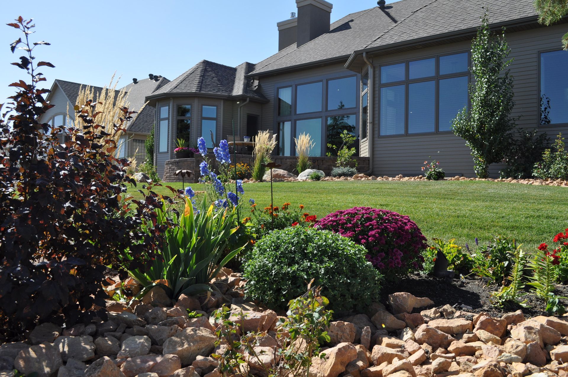 A house with a lot of windows and flowers in front of it