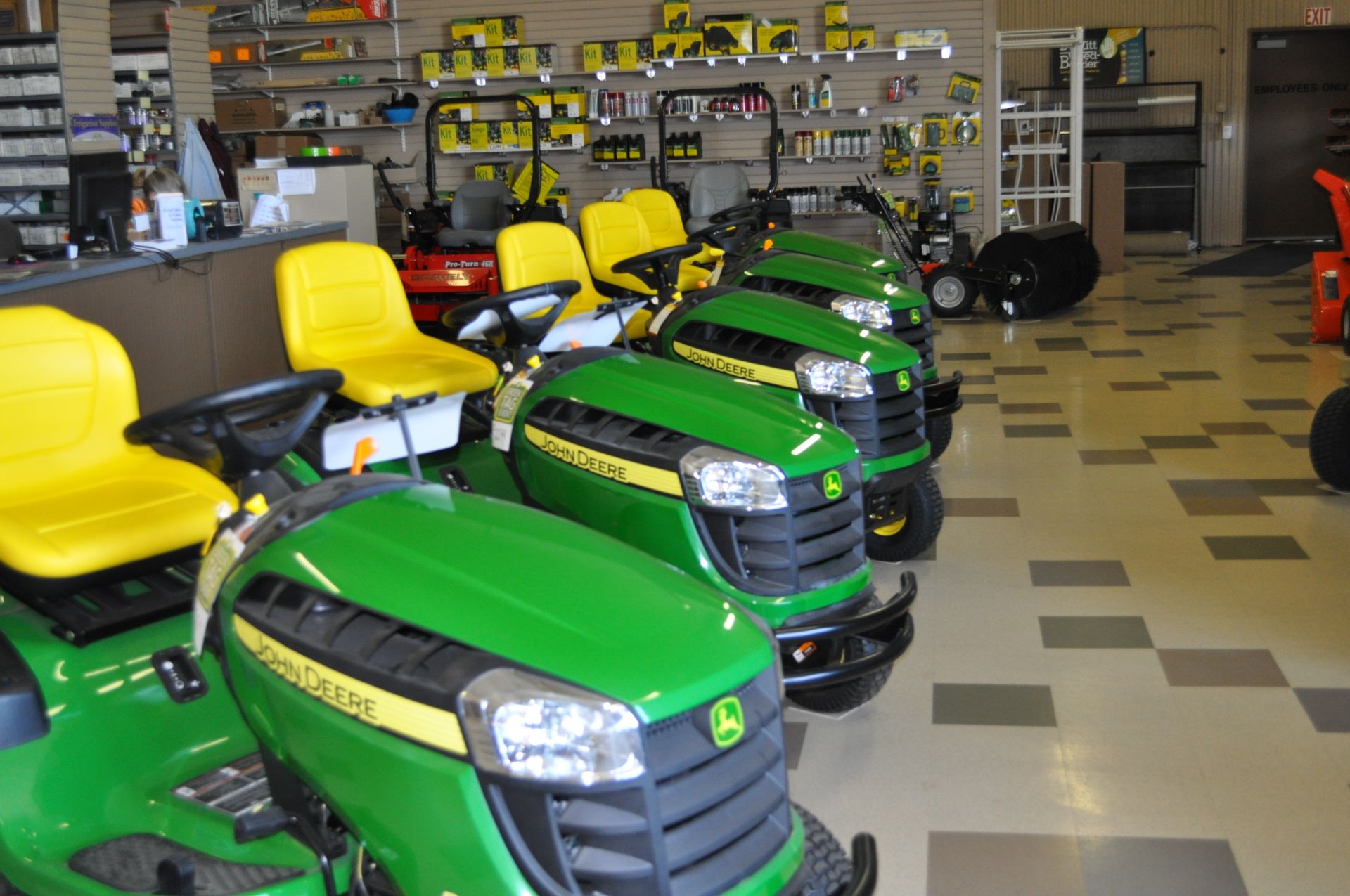 A row of john deere lawn mowers are lined up in a store