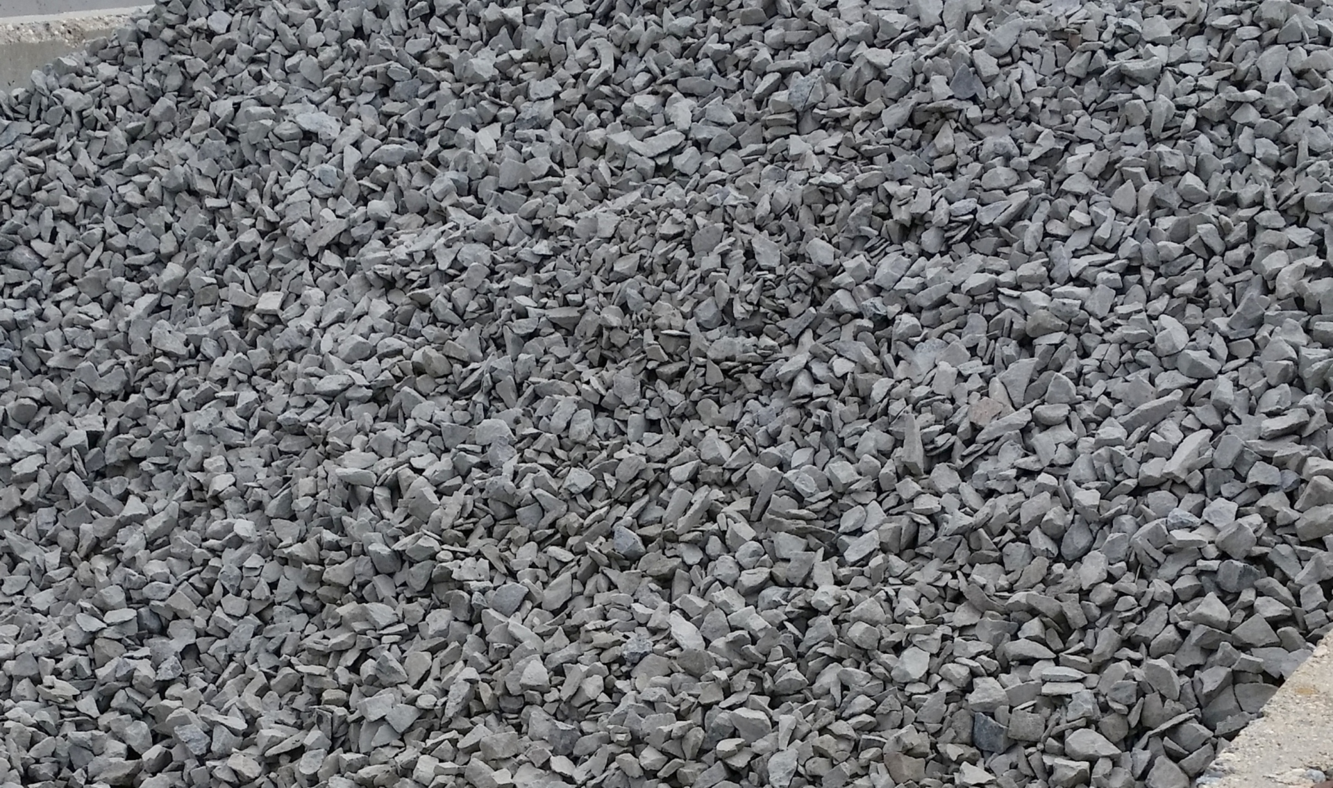 A pile of gravel is sitting on top of a concrete surface.
