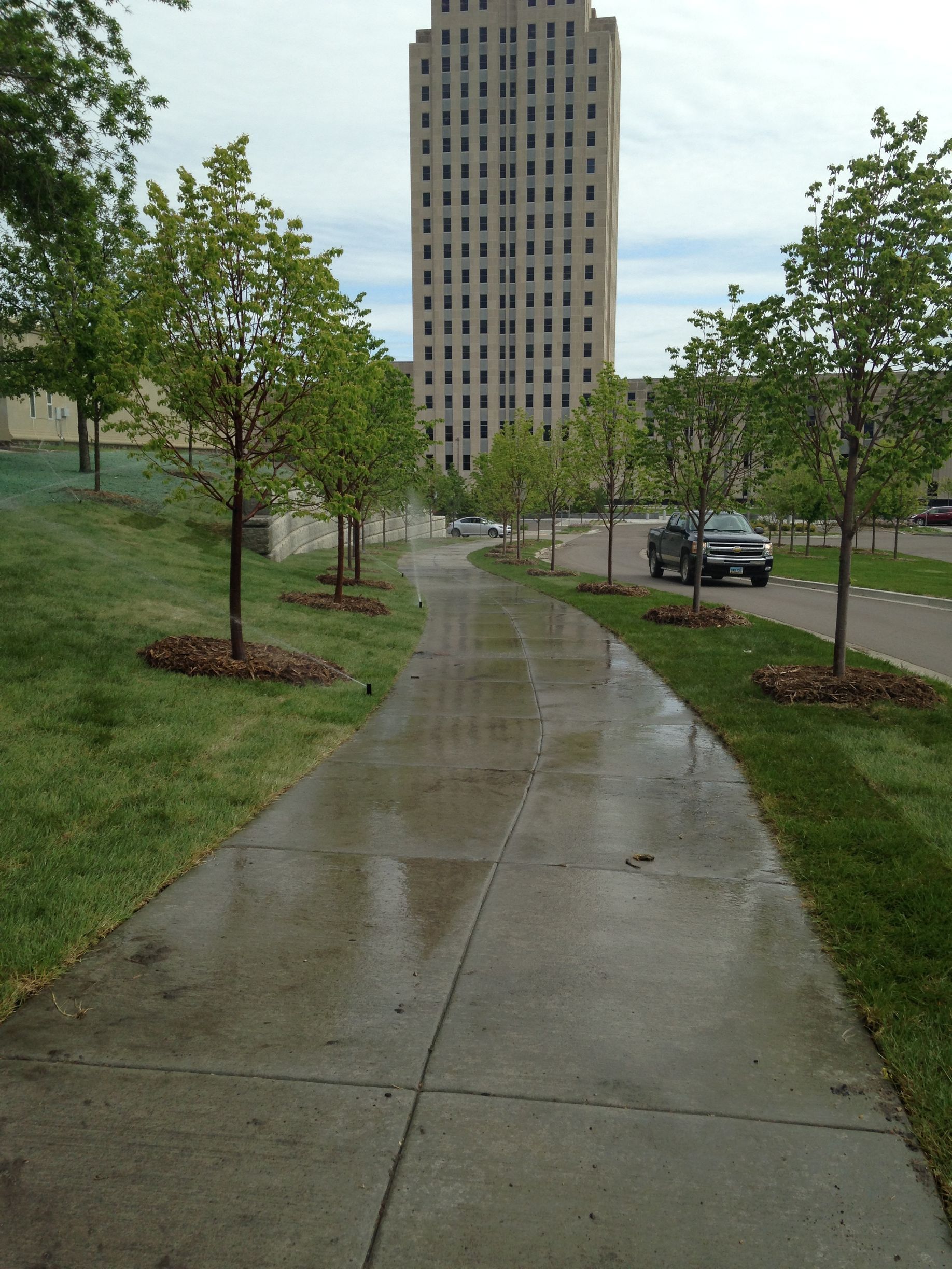 A sidewalk with a tall building in the background