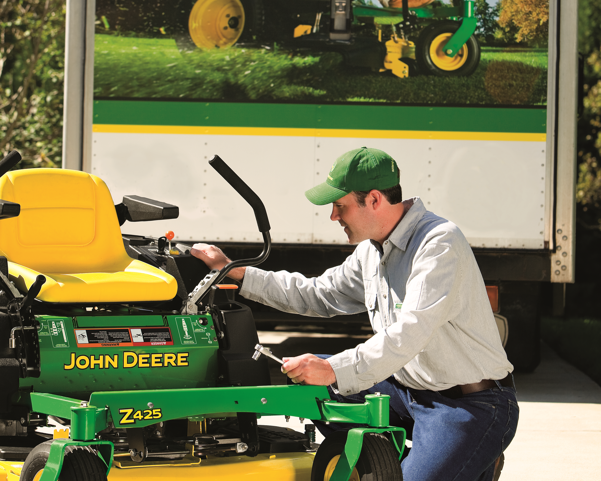 A man is working on a john deere lawn mower