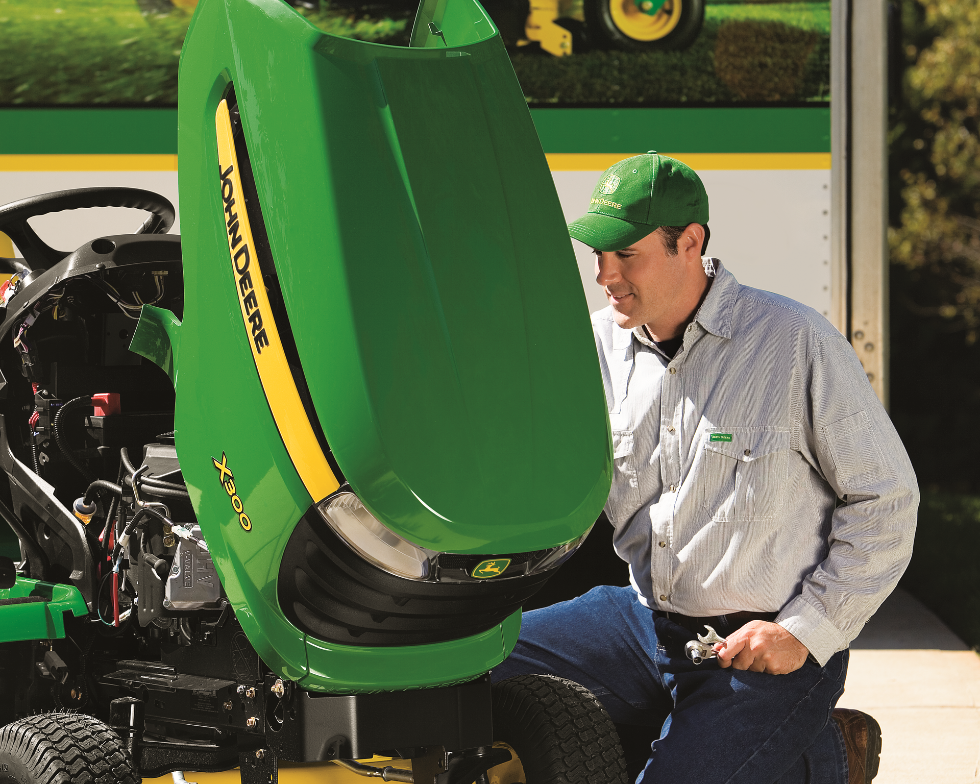 A man is working on a john deere lawn mower