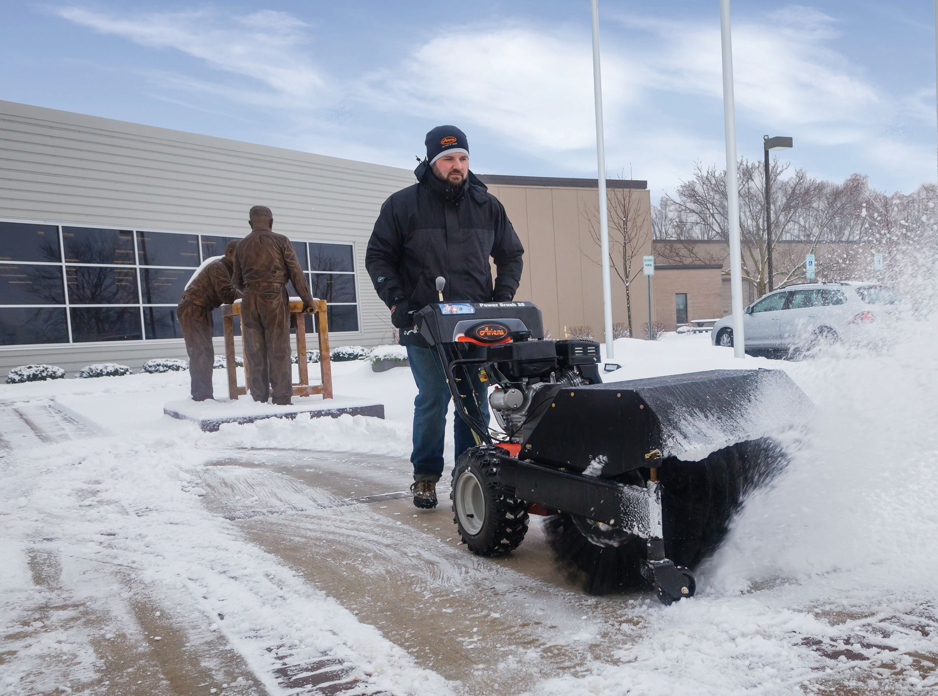 A man is using a snow blower to clear snow from a sidewalk