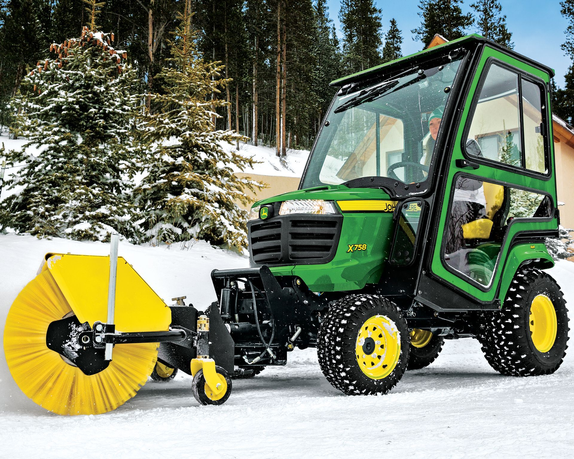 A john deere tractor with a snow blower attached to it