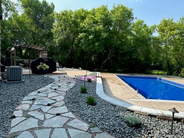 A swimming pool with a stone walkway leading to it