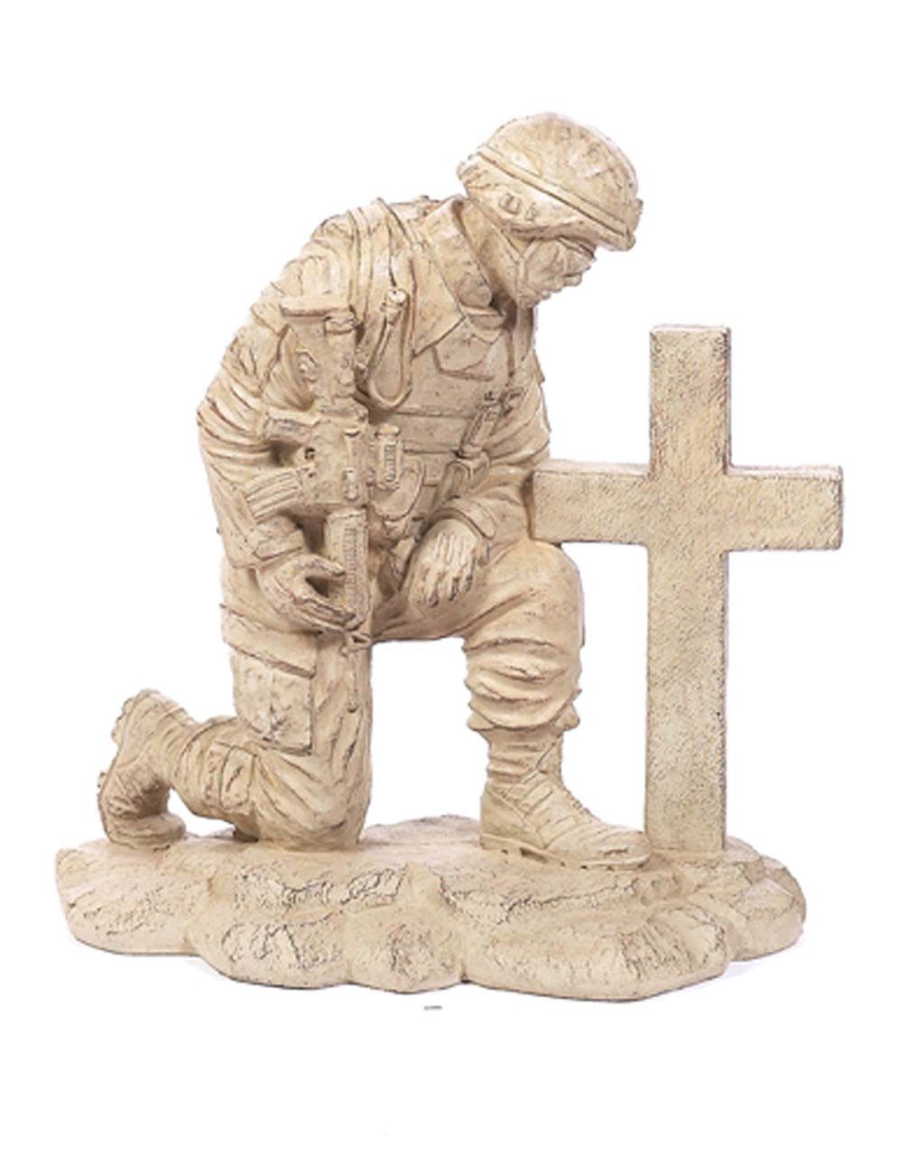Statue of a soldier kneeling at a cross, head bowed. Beige tones, uniform, somber expression.