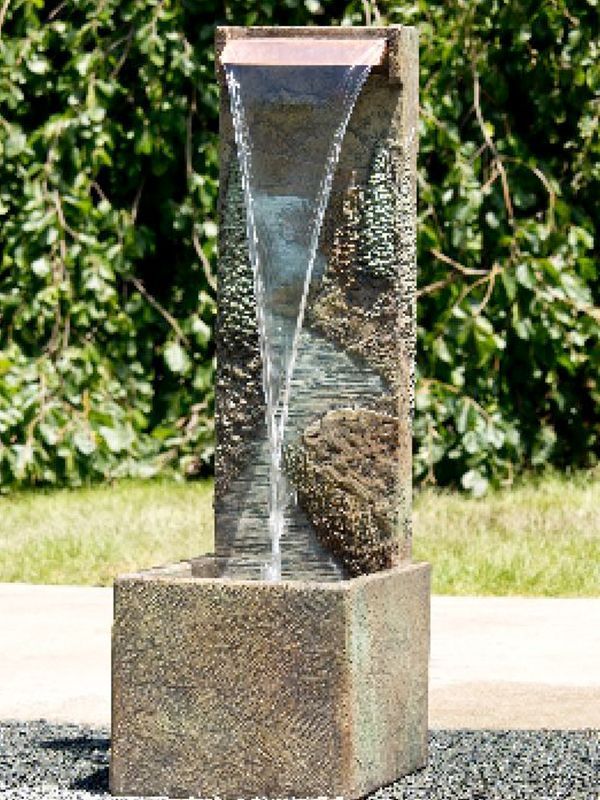 Stone water fountain with water cascading down; outdoor setting.