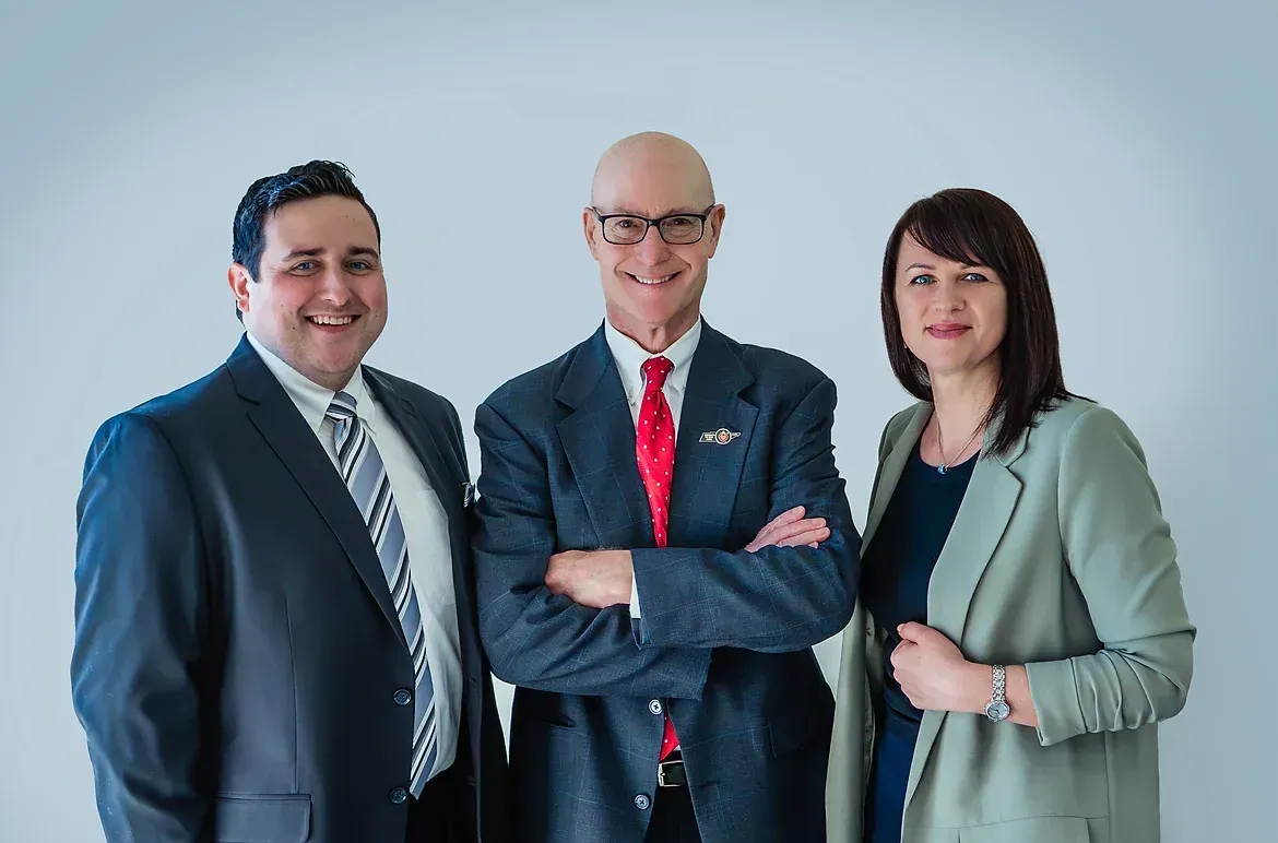 Three people in suits and ties are posing for a picture.