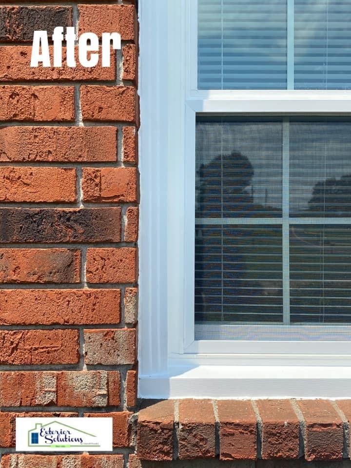 Brick exterior window with white trim, blinds, and a 