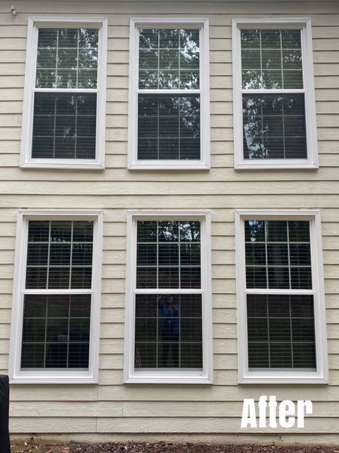Six white-framed windows on beige siding. Blinds are visible in the lower three windows.